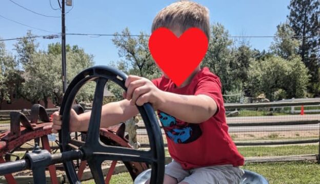 J driving a tractor at age 4